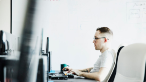 Individual sitting at a desk working on their computer
